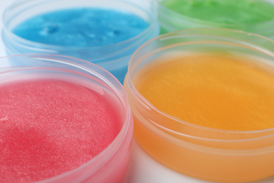 Colorful slimes in plastic containers, closeup. Antistress toy