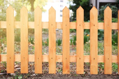 Photo of Closeup view of wooden fence outdoors on sunny day