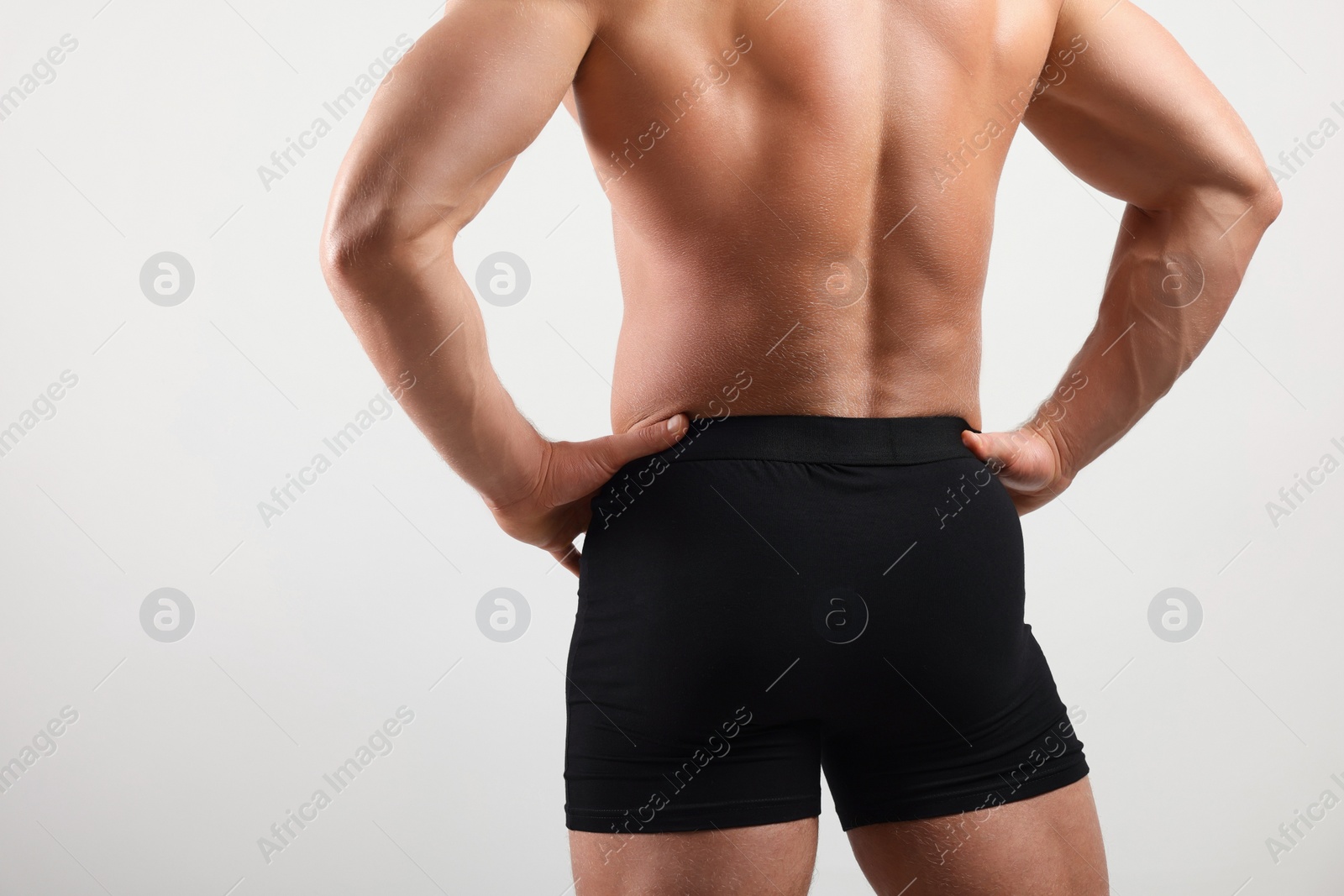 Photo of Young man is stylish black underwear on light grey background, closeup