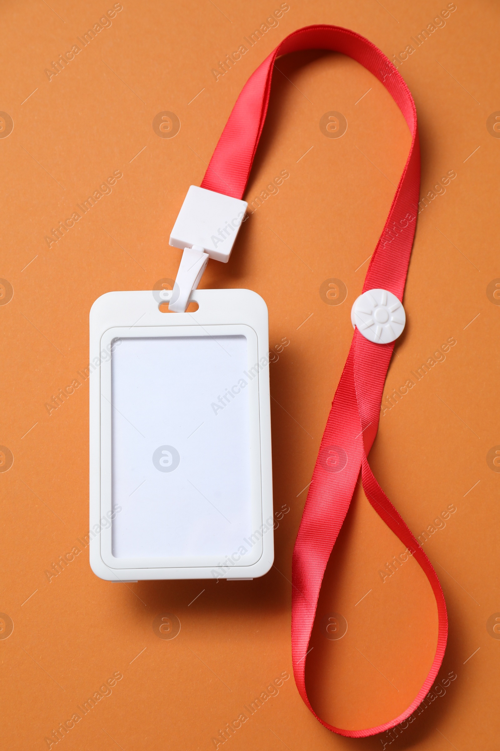 Photo of Blank badge with string on orange background, top view