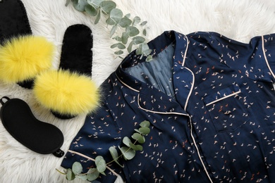 Photo of Flat lay composition with fluffy slippers and pajamas on fuzzy carpet. Comfortable home outfit