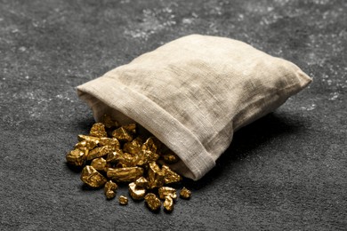 Photo of Overturned sack of gold nuggets on grey table