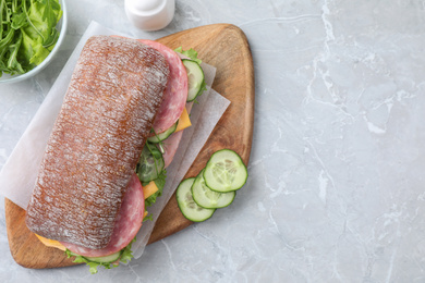 Photo of Tasty sandwich with ham on grey table, flat lay. Space for text
