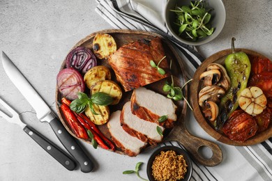 Photo of Delicious grilled meat and vegetables served on light grey table, flat lay