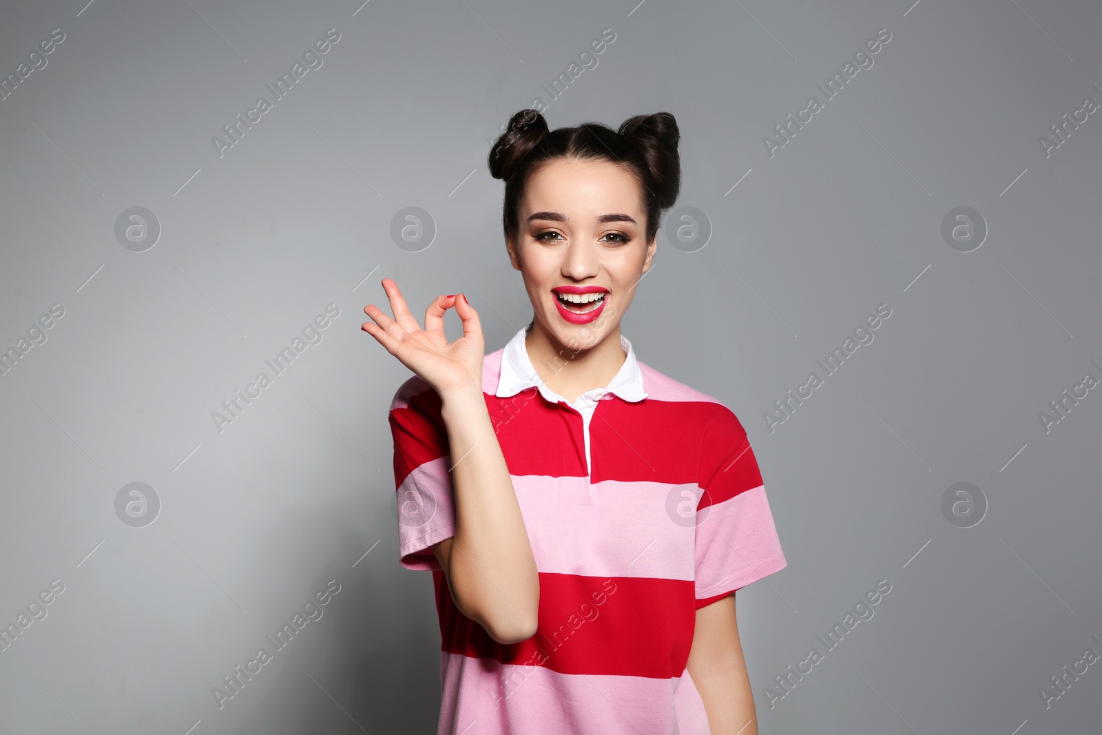 Photo of Portrait of beautiful young woman on grey background