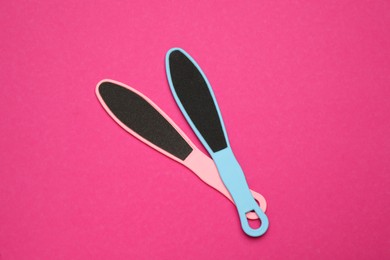 Photo of Colorful foot files on pink background, flat lay. Pedicure tools