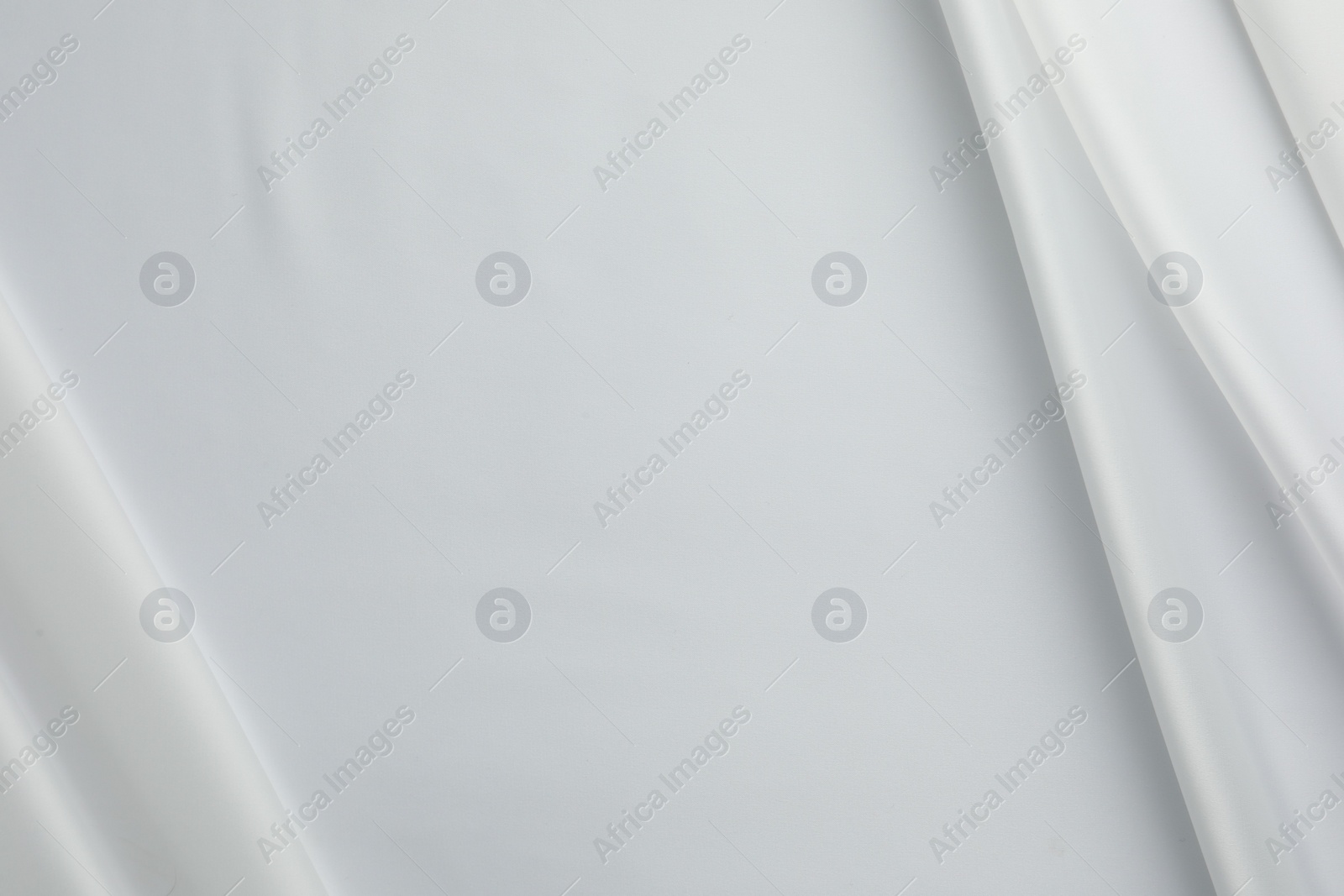Photo of Texture of crumpled white silk fabric as background, top view. Space for text