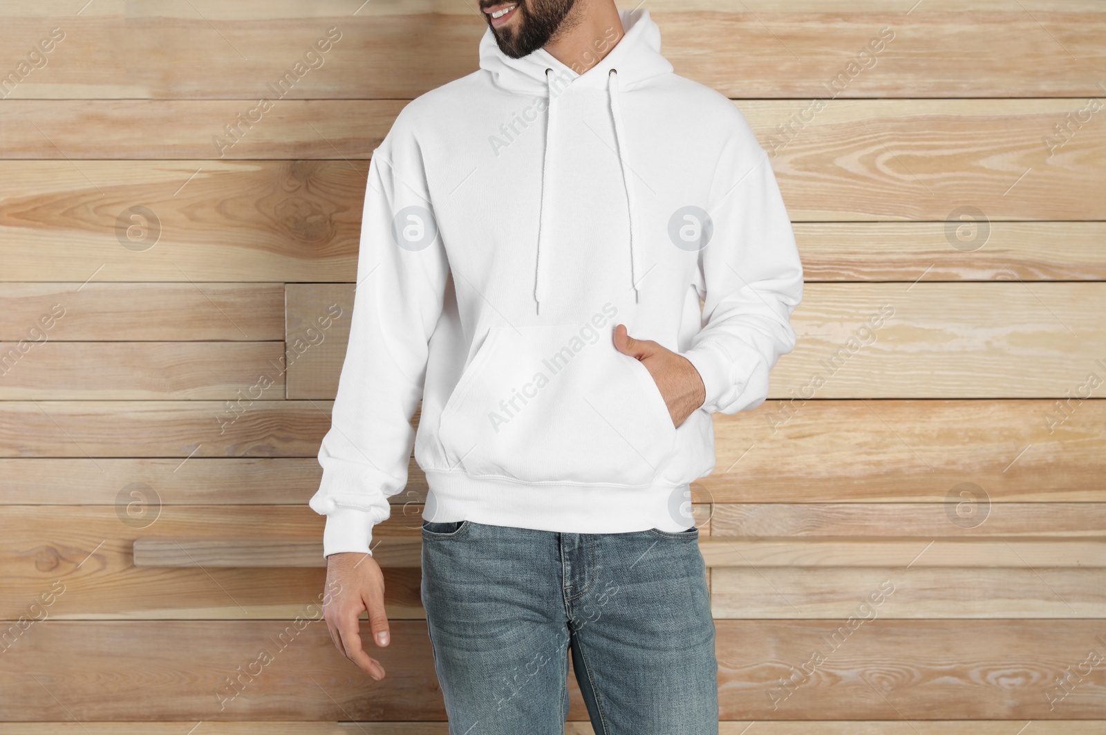 Photo of Young man in sweater at wooden wall, closeup. Mock up for design