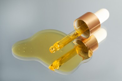 Photo of Yellow serum with pipette on mirror, closeup