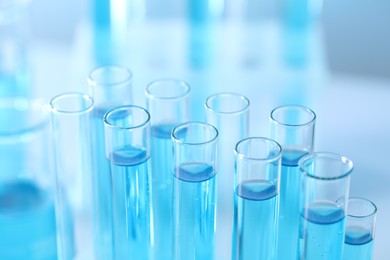 Photo of Test tubes with light blue liquid in laboratory, closeup