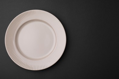 Photo of One clean plate on black background, top view. Space for text