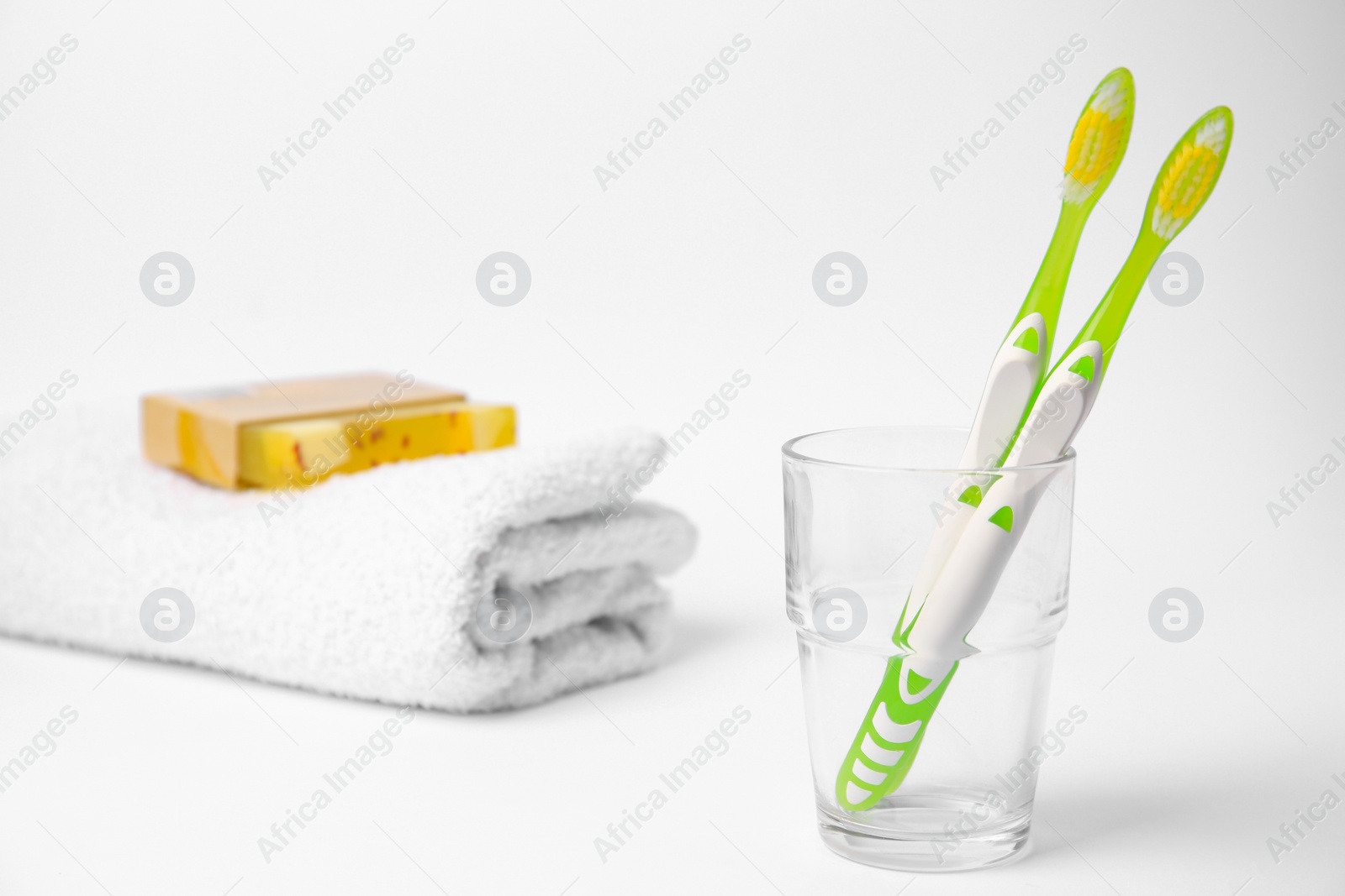 Photo of Light green toothbrush in glass holder on white background
