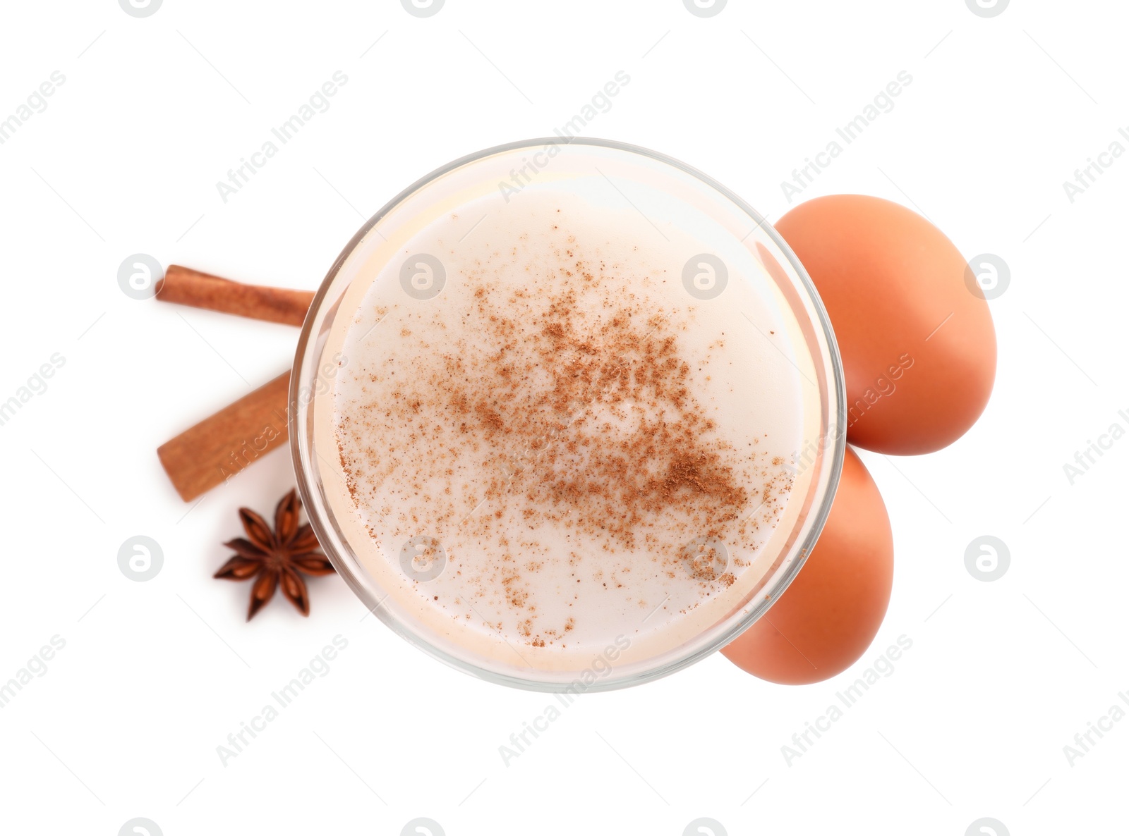 Photo of Delicious eggnog in glass, spices and eggs isolated on white, top view