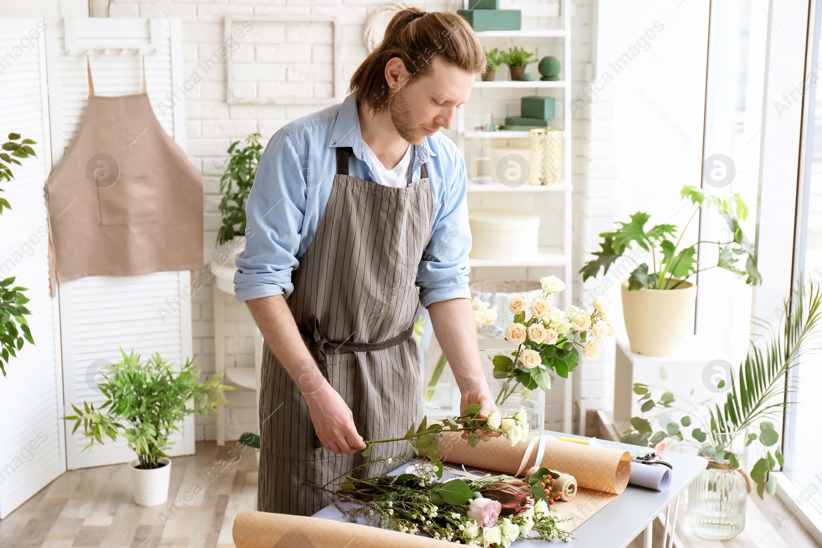Photo of Male florist creating bouquet at workplace