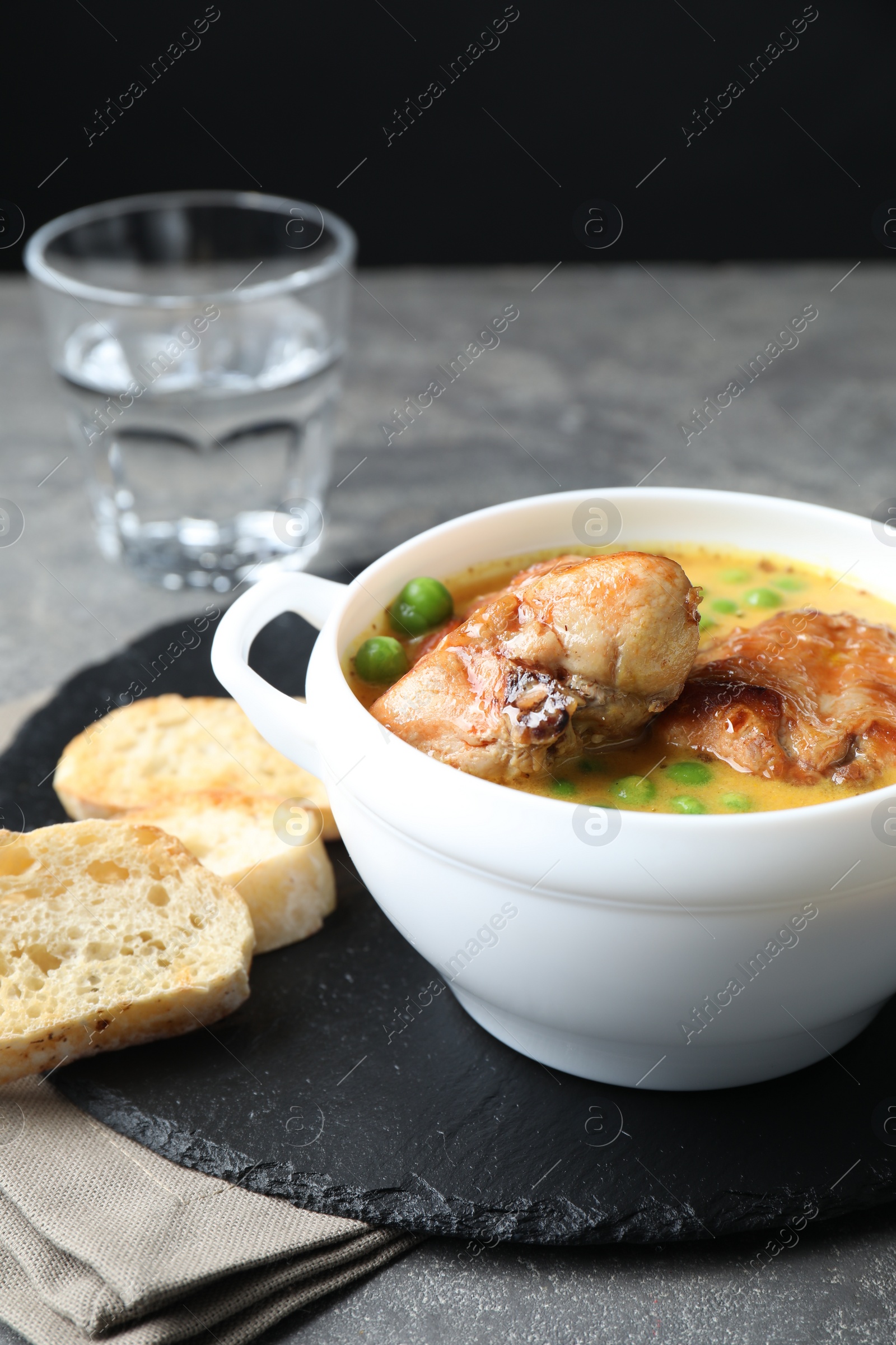 Photo of Tasty cooked rabbit meat with sauce served on grey table, closeup