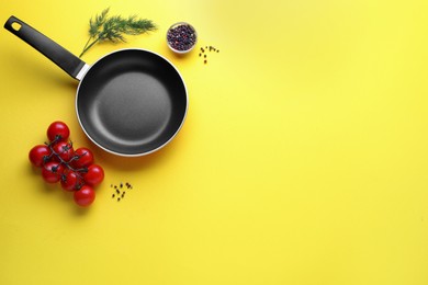 Photo of Flat lay composition with frying pan and fresh products on yellow background, space for text