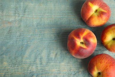 Photo of Fresh juicy peaches on blue wooden table, top view with space for text