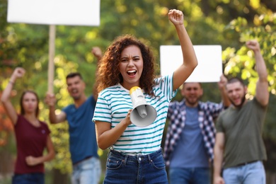Photo of Angry African-American woman with megaphone at protest outdoors