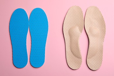 Photo of Pairs of breathable shoe insoles on pink background, flat lay