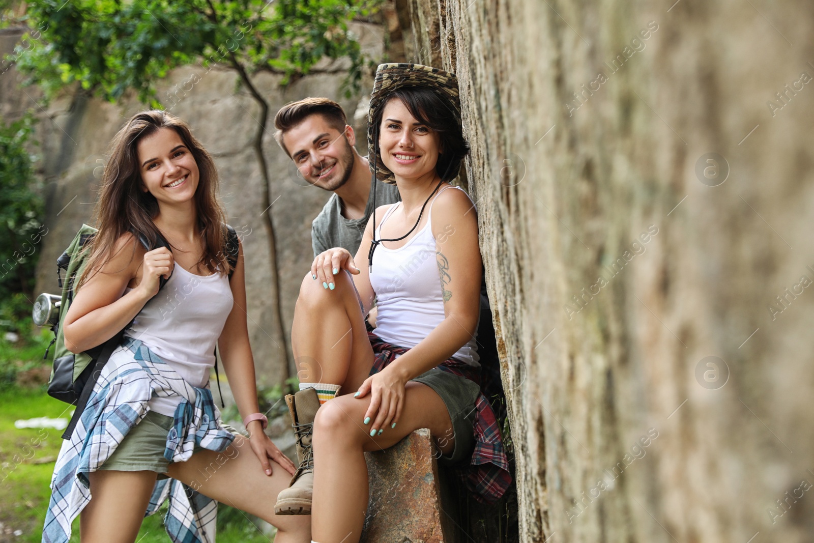 Photo of Young friends near steep cliff on summer day. Camping season