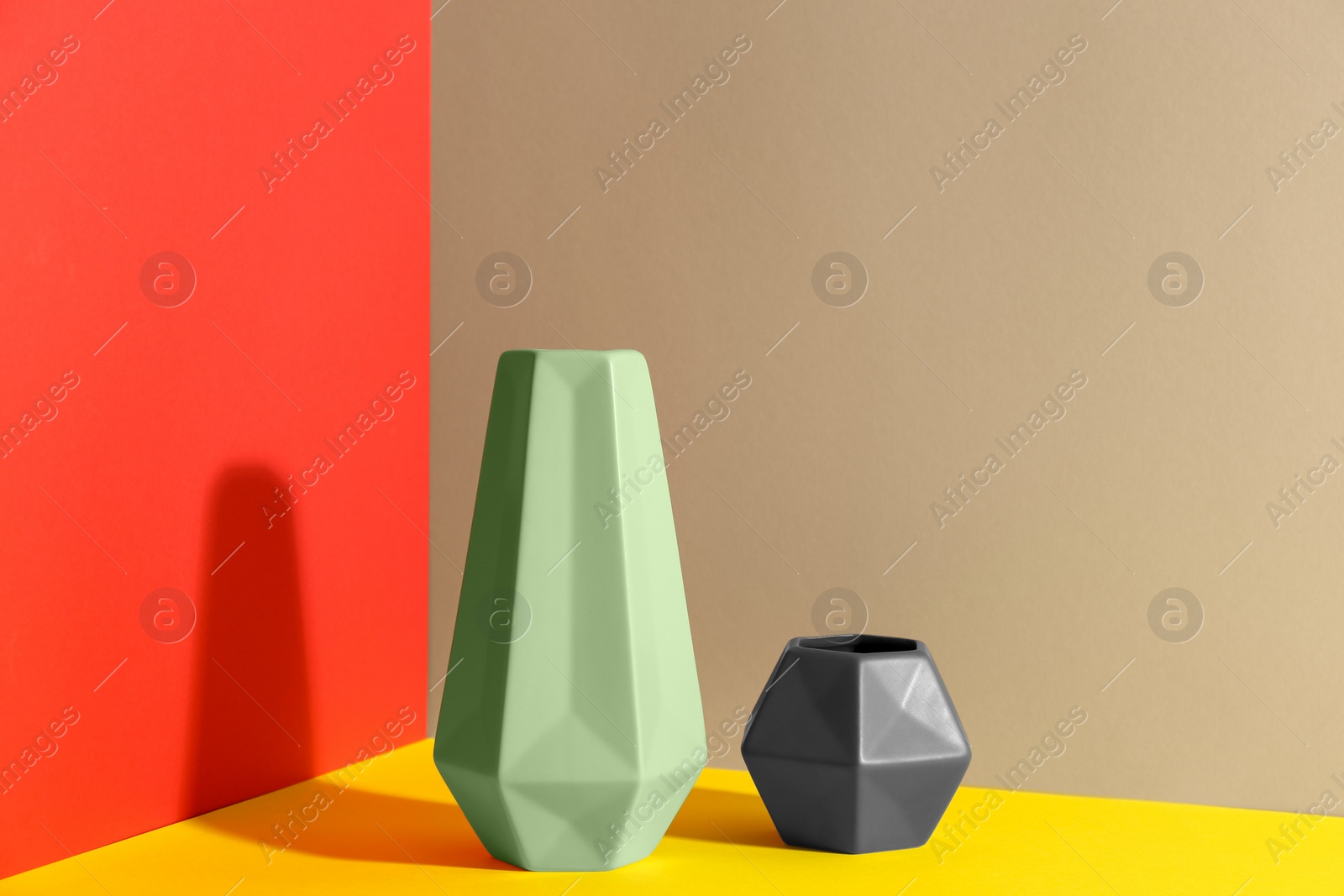 Photo of Stylish empty ceramic vases on color background