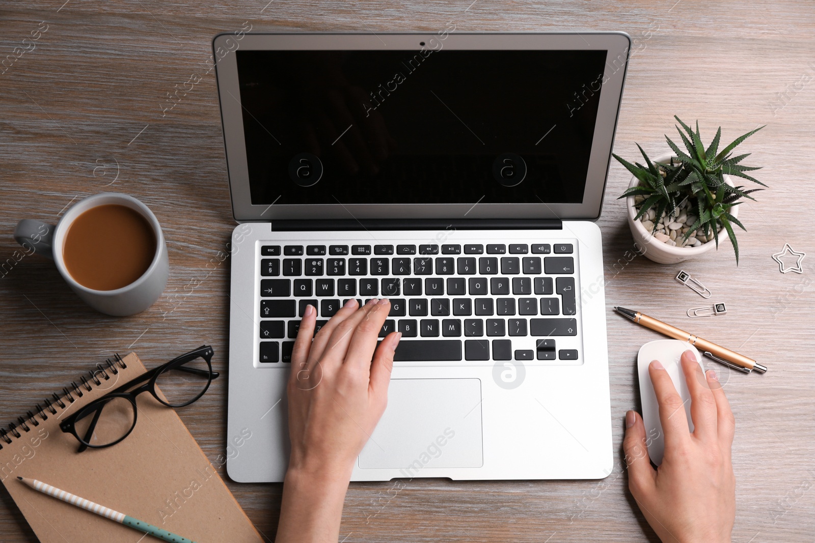 Photo of Woman using computer mouse with laptop at office table, top view