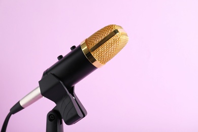 Condenser microphone on color background, space for text