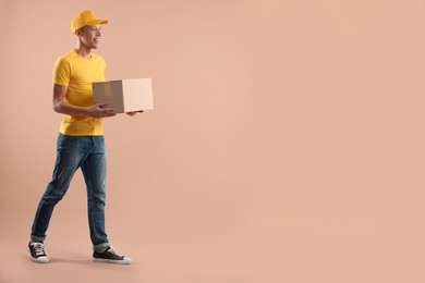 Photo of Happy courier with parcel on beige background. Space for text