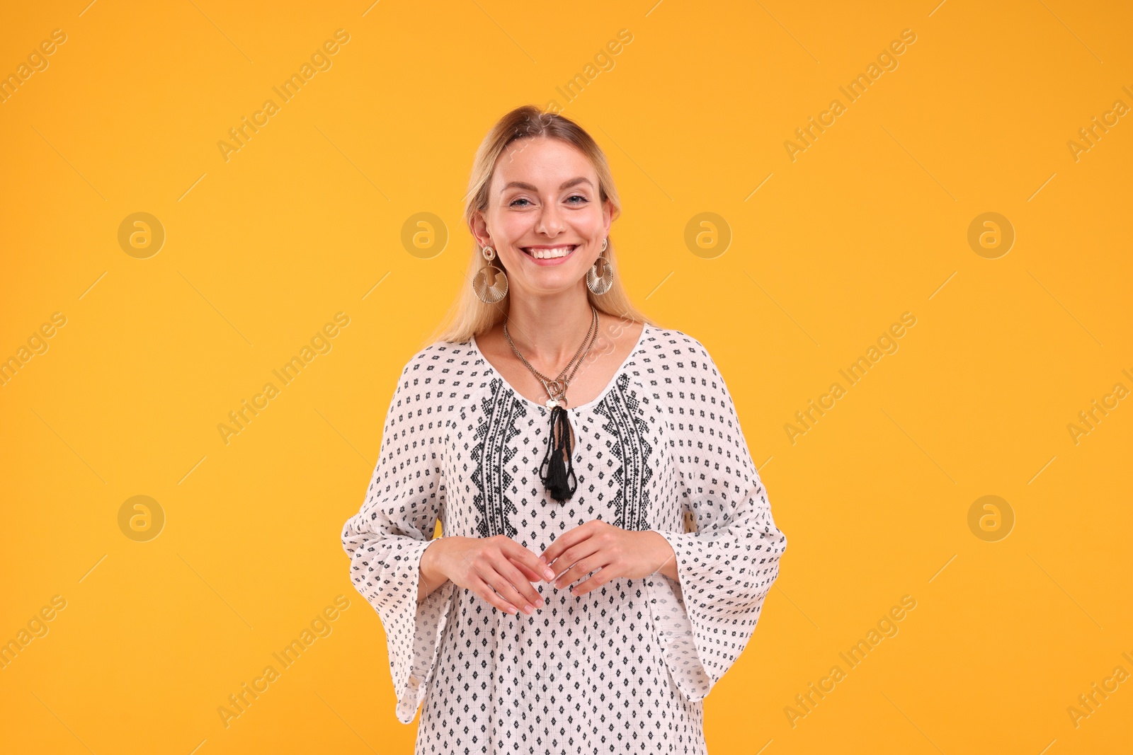 Photo of Portrait of smiling hippie woman on yellow background