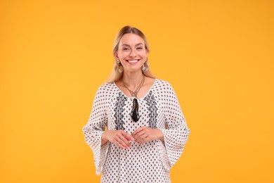 Portrait of smiling hippie woman on yellow background