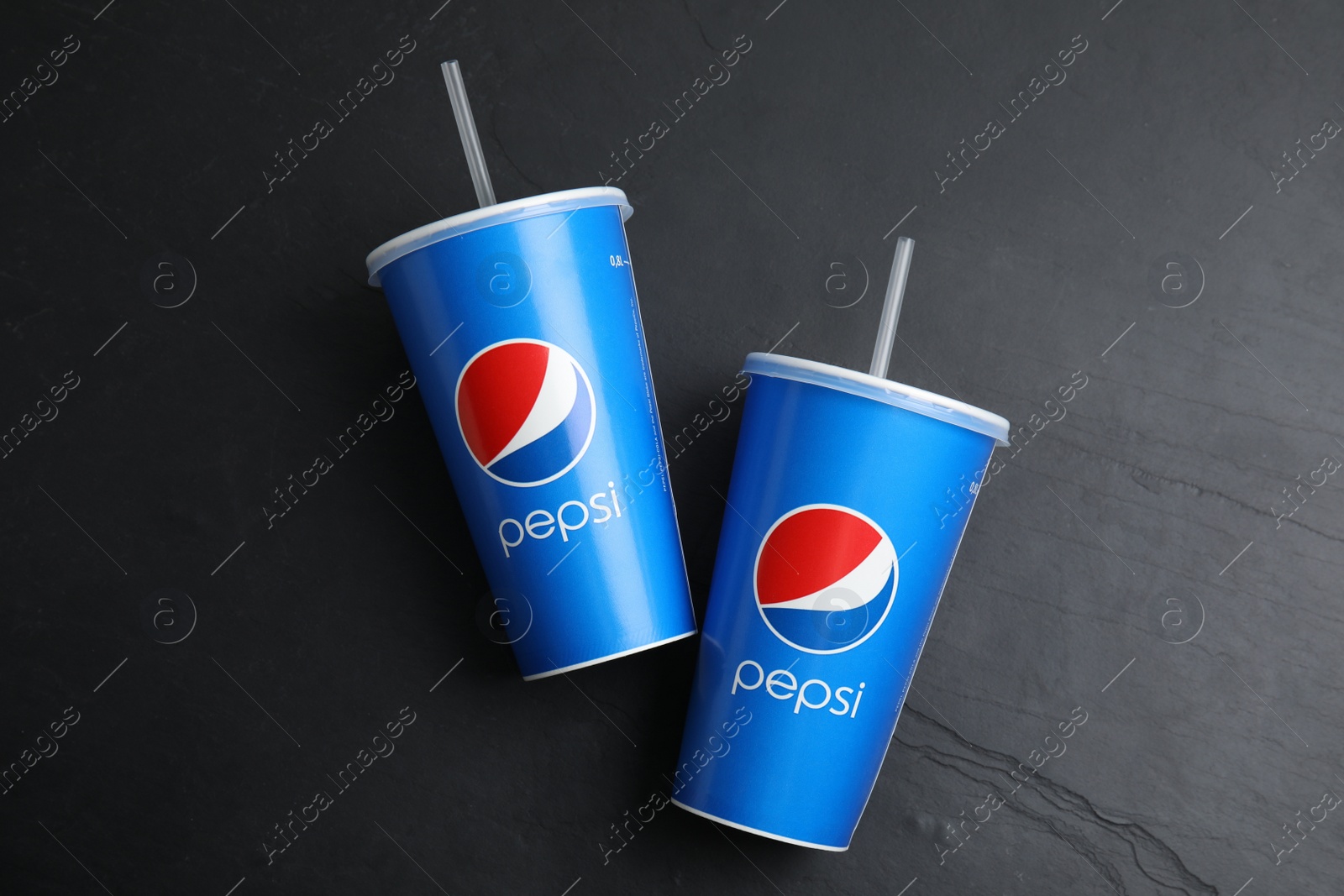 Photo of MYKOLAIV, UKRAINE - JUNE 08, 2021: Paper Pepsi cups on black background, flat lay