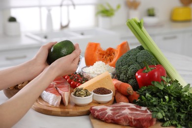 Photo of Woman and healthy food at white table, closeup. Keto diet