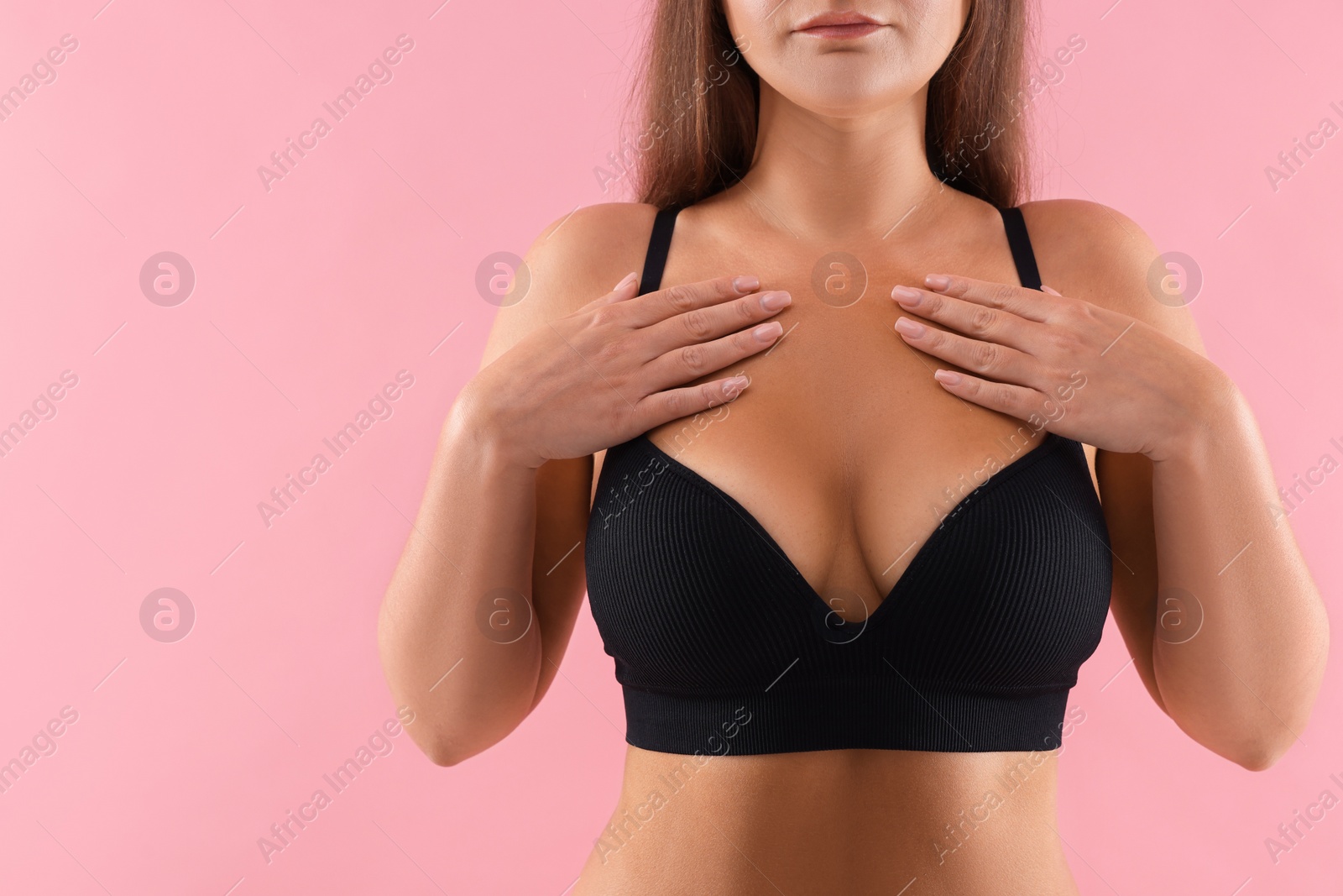 Photo of Woman with beautiful breast on pink background, closeup. Space for text