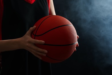 Photo of Basketball player with ball on black background, closeup