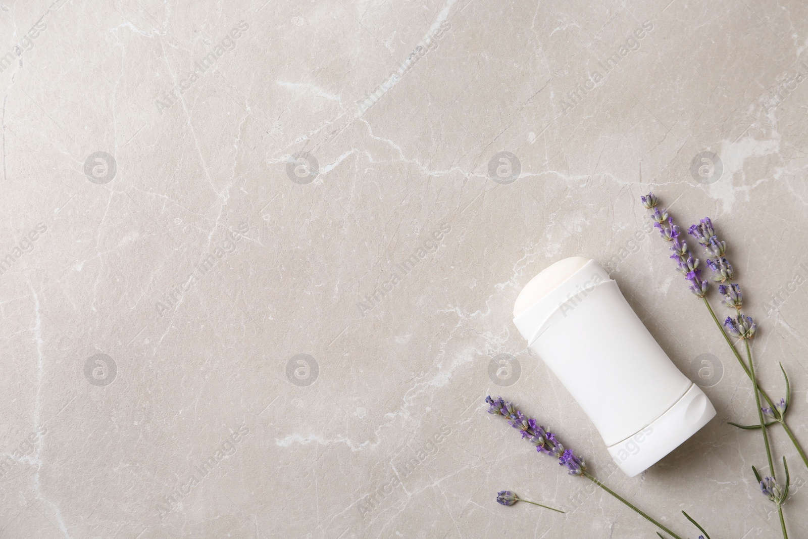 Photo of Female deodorant and lavender flowers on marble background, flat lay. Space for text