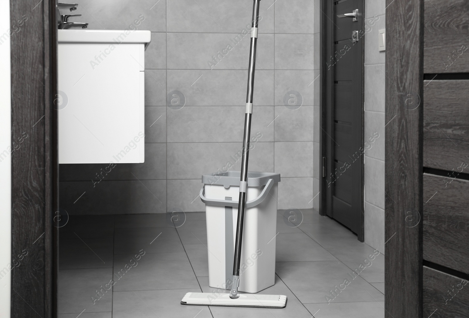 Photo of Mop and bucket in public toilet. Cleaning floor