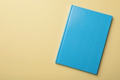 New light blue planner on beige background, top view. Space for text