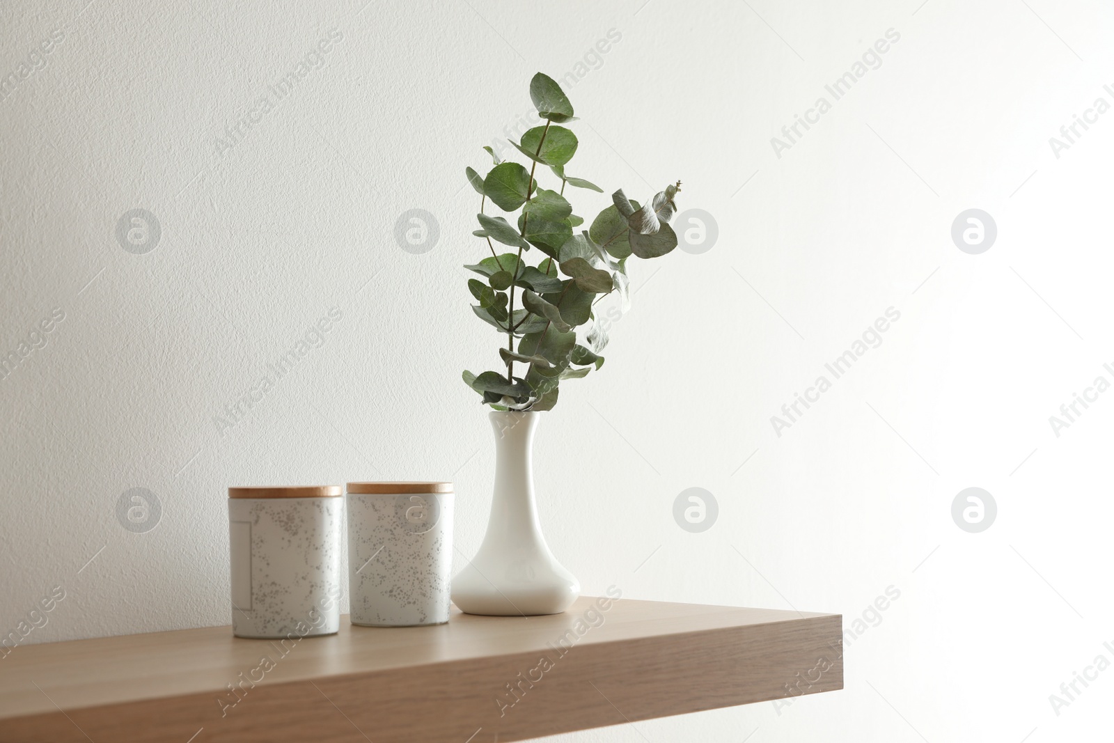 Photo of Wooden shelf with decorative elements on light wall