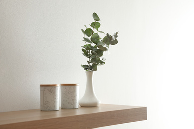 Photo of Wooden shelf with decorative elements on light wall