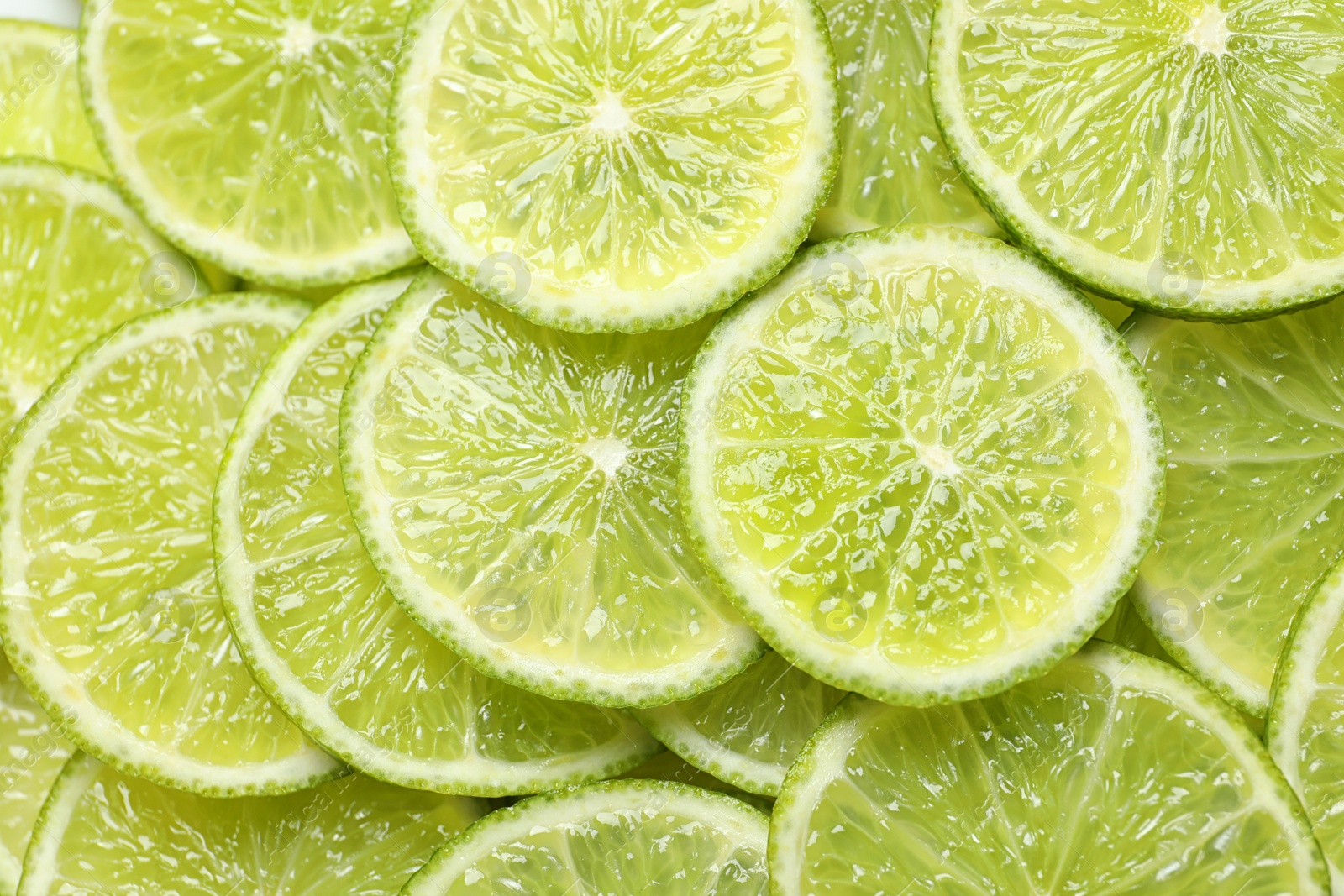 Photo of Fresh sliced ripe limes as background, top view