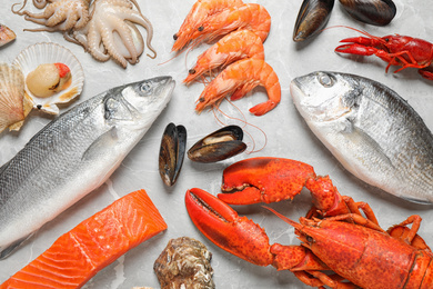 Fresh fish and seafood on marble table, flat lay