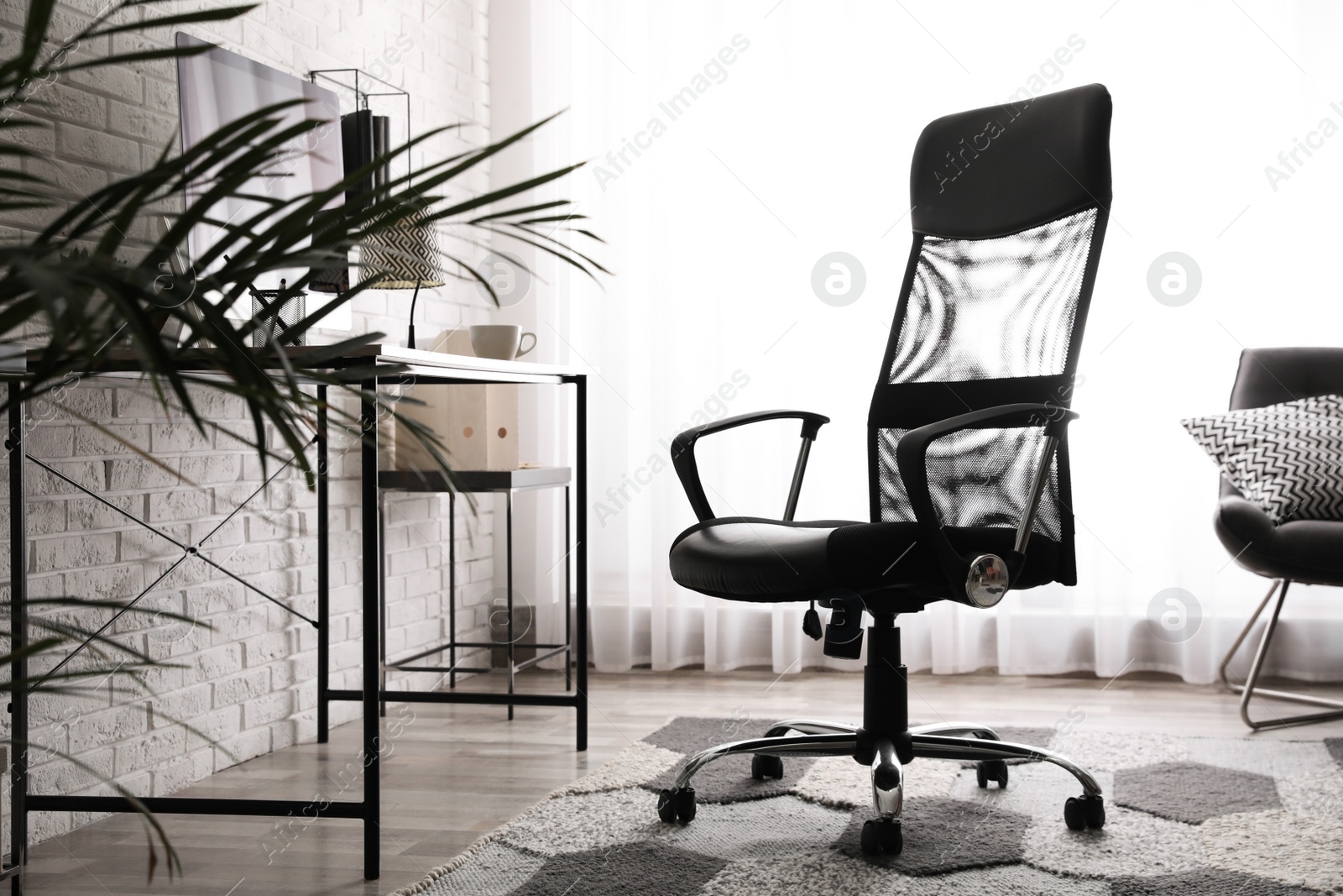 Photo of Comfortable chair near desk in modern office interior