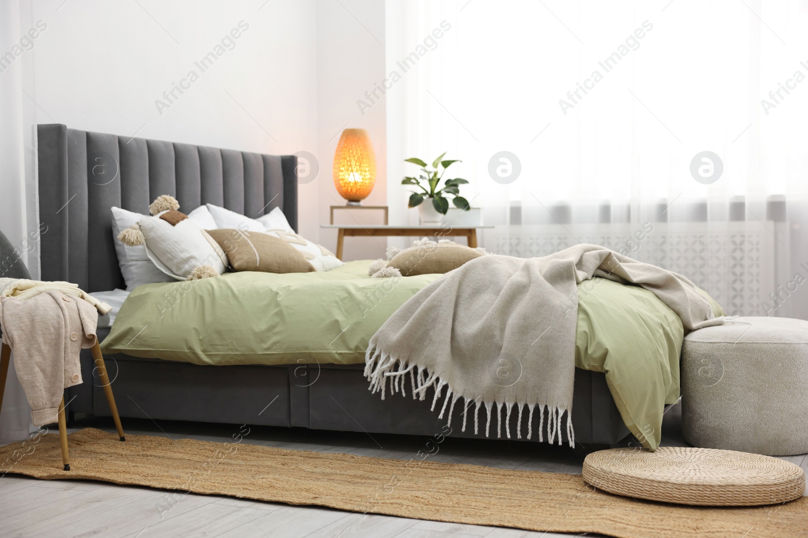Photo of Soft plaid on bed in stylish bedroom