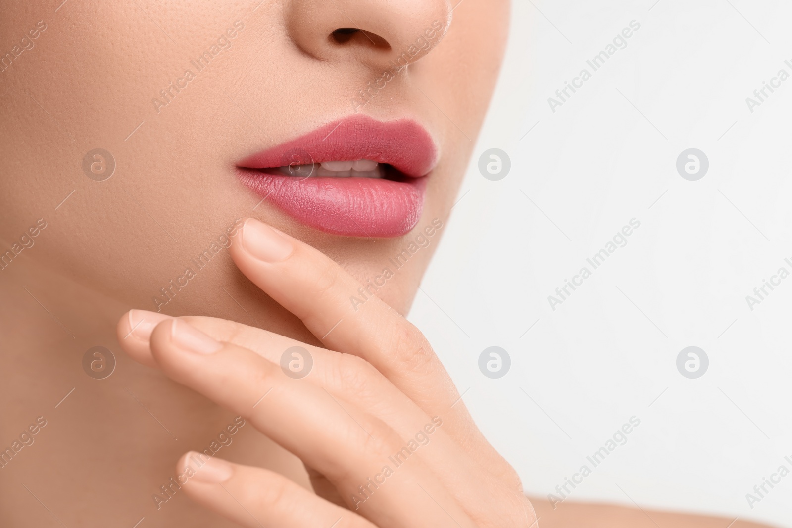 Photo of Young woman with beautiful full lips on white background, closeup