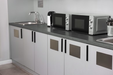 Kitchen appliances on grey countertop in hostel