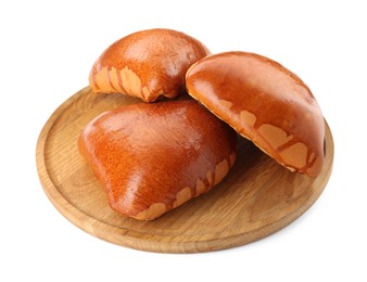 Wooden board with delicious baked patties on white background