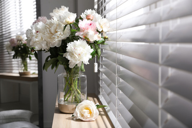 Photo of Bouquet of beautiful peony flowers on window sill indoors