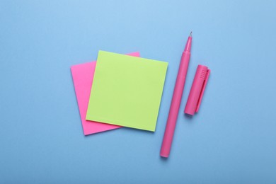 Photo of Paper notes and color marker on light blue background, flat lay
