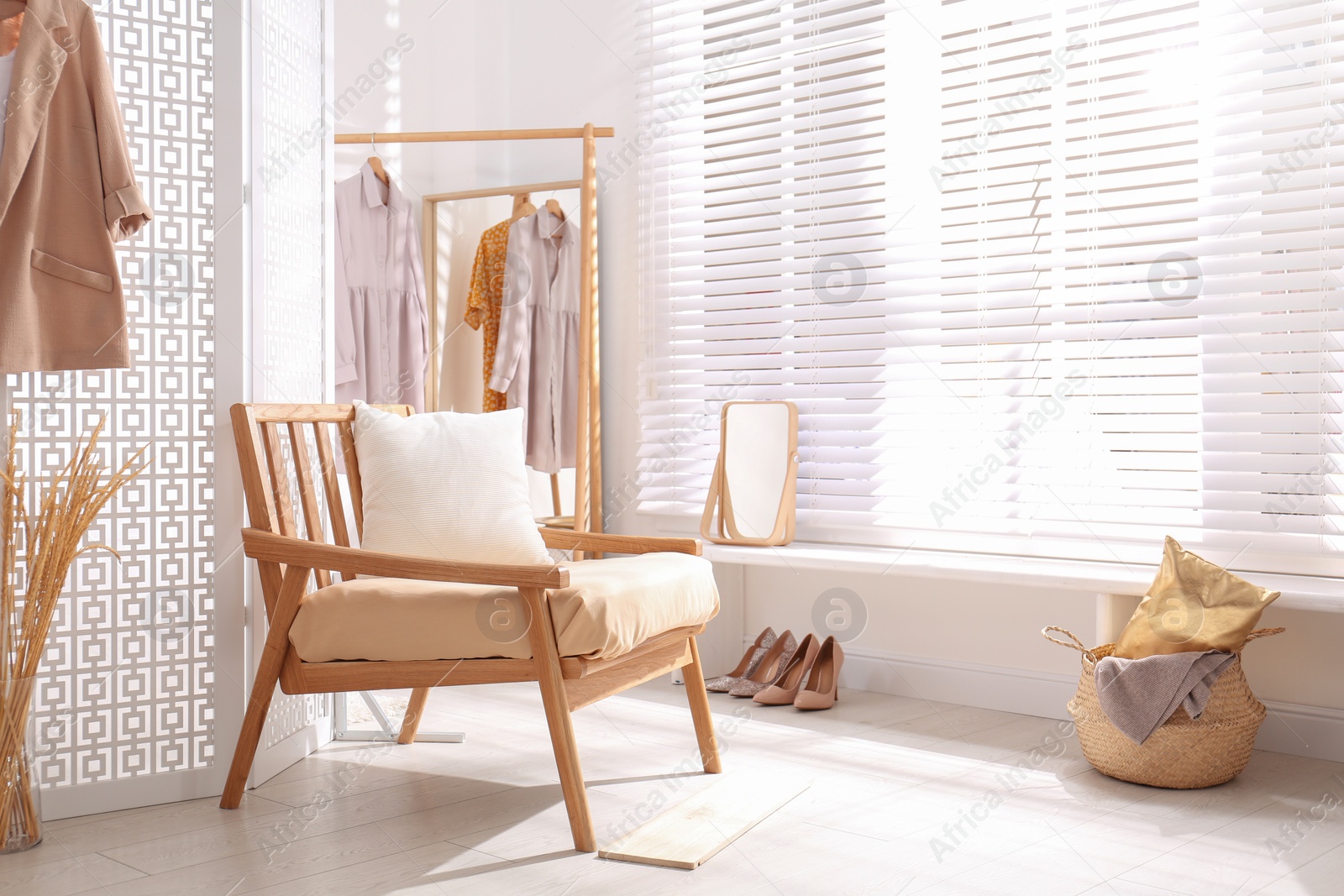 Photo of Stylish room interior with white folding screen and armchair