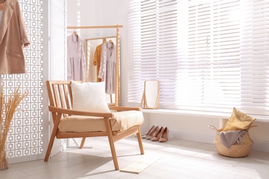 Photo of Stylish room interior with white folding screen and armchair